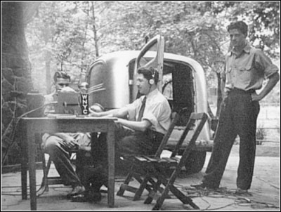 �This photo, ca. 1938, shows the author Edward Golub with earphones, center, on location with WNYC
